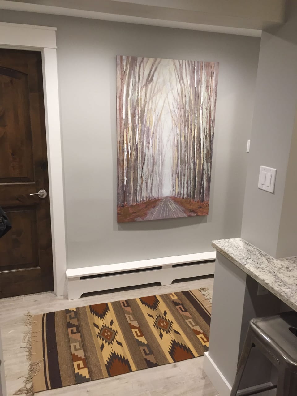 Entry way with tile floors and baseboard heater to keep your boots warm.