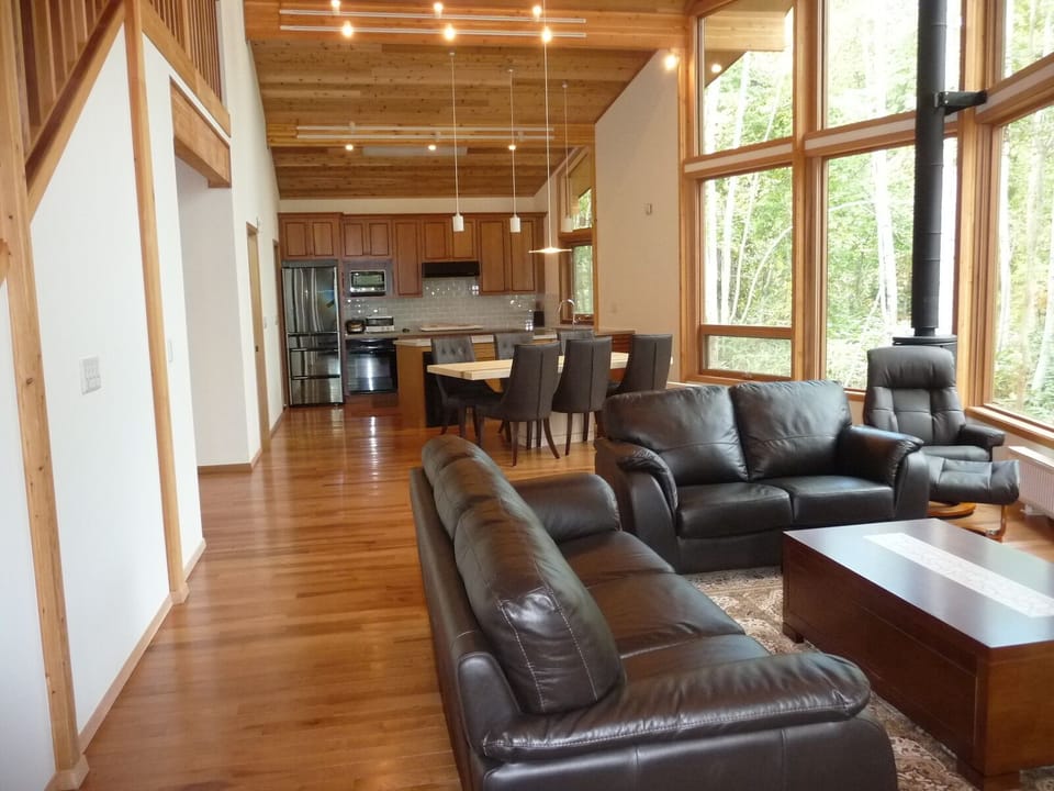 View of living and dining rooms with open kitchen design.