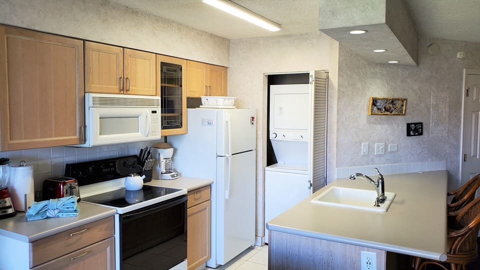 Kitchen with all the necessities to eat in and BBQ at the grills downstairs