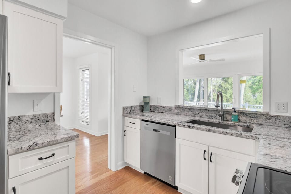 Your fully equipped kitchen awaits with granite counters, stainless appliances, and peaceful garden views.