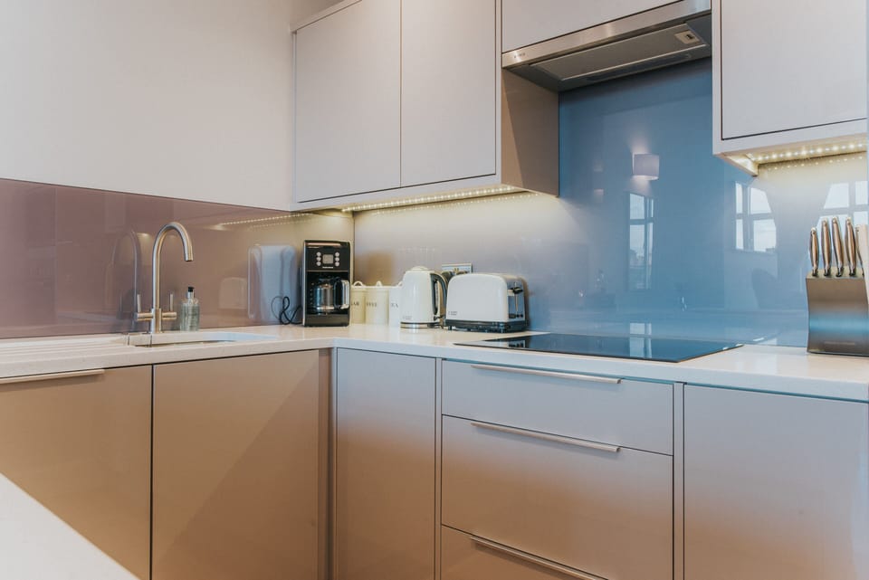 The kitchen has a thistle coloured glass splshback