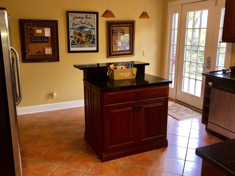 Kitchen island and back door to back porch, tables and chairs.