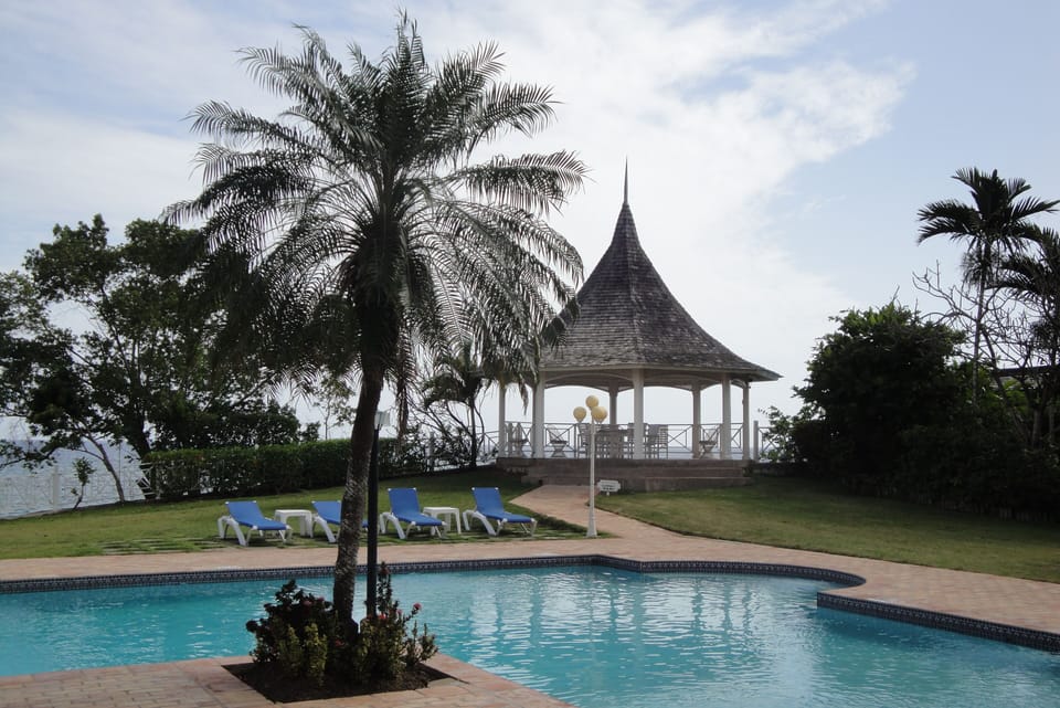 View of the Gazebo from the pool area with cushioned chairs and tables.