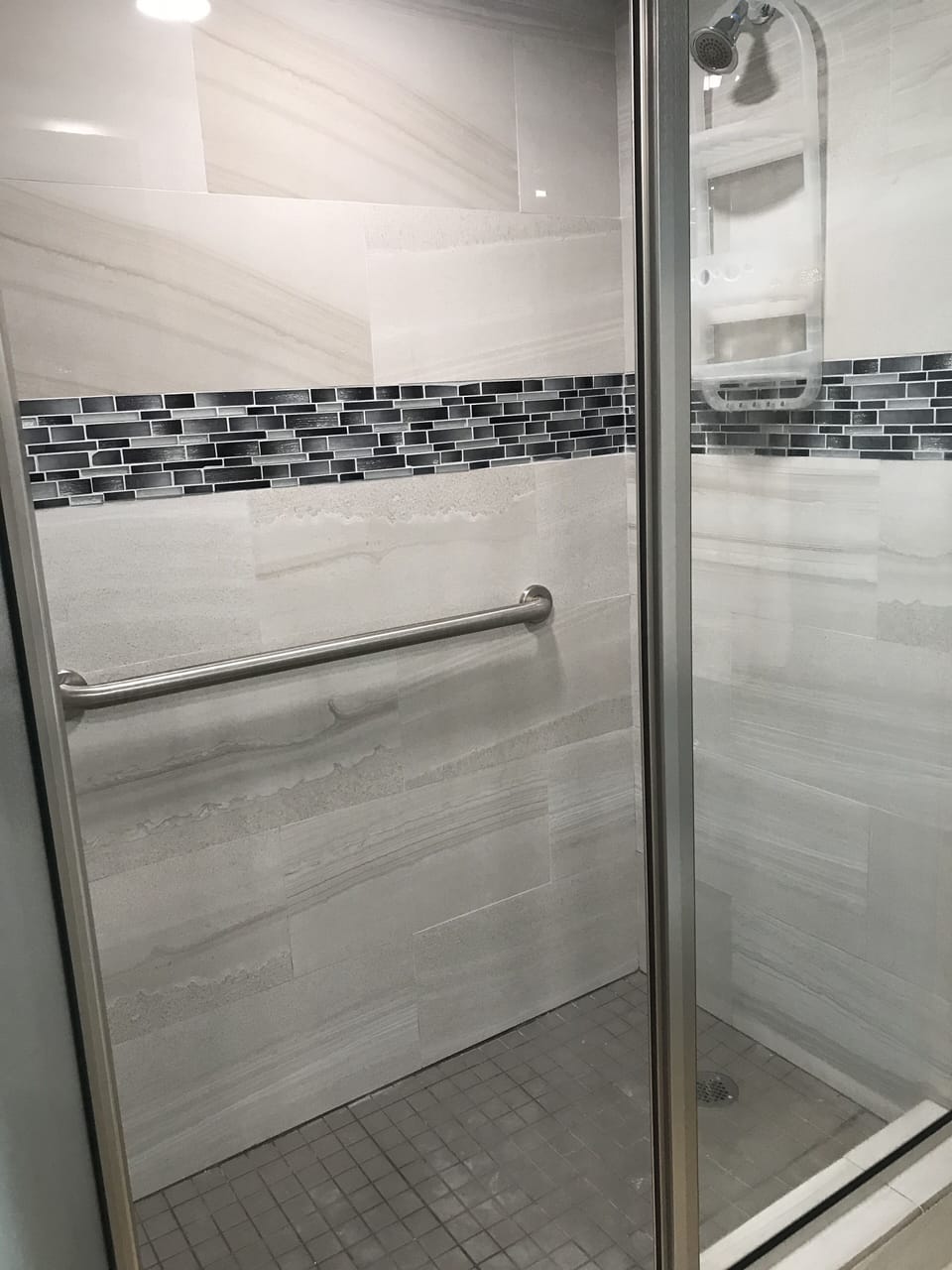 Beautiful new walk in shower with pivot door and safety rails.