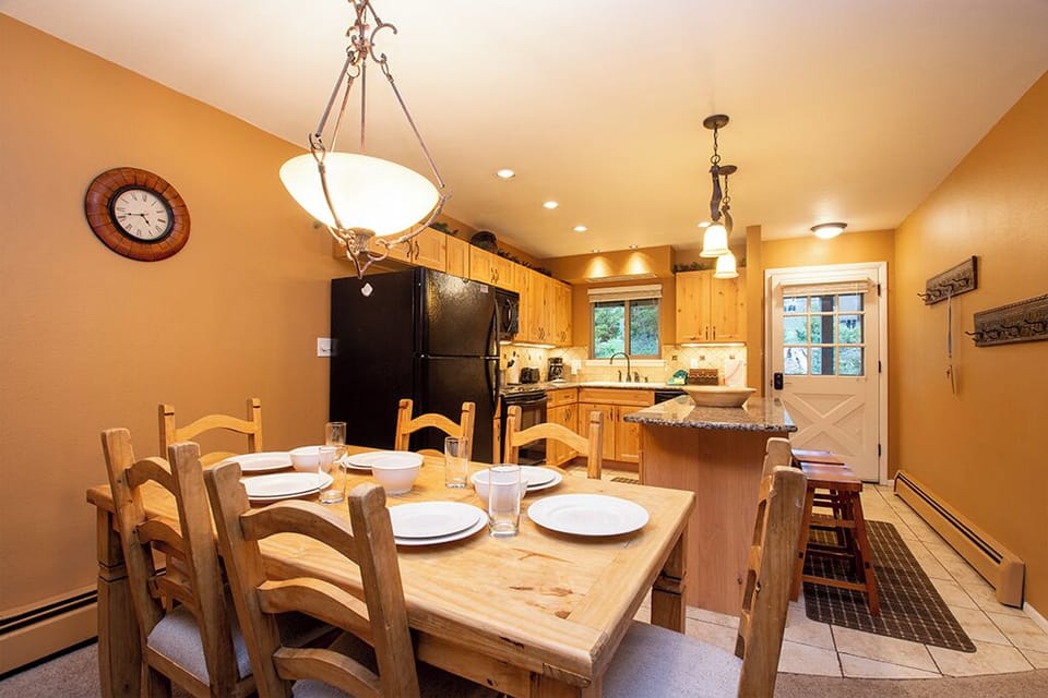 Gather around this inviting dining table where warm wood tones and thoughtful lighting create the perfect setting for your memorable meals together.