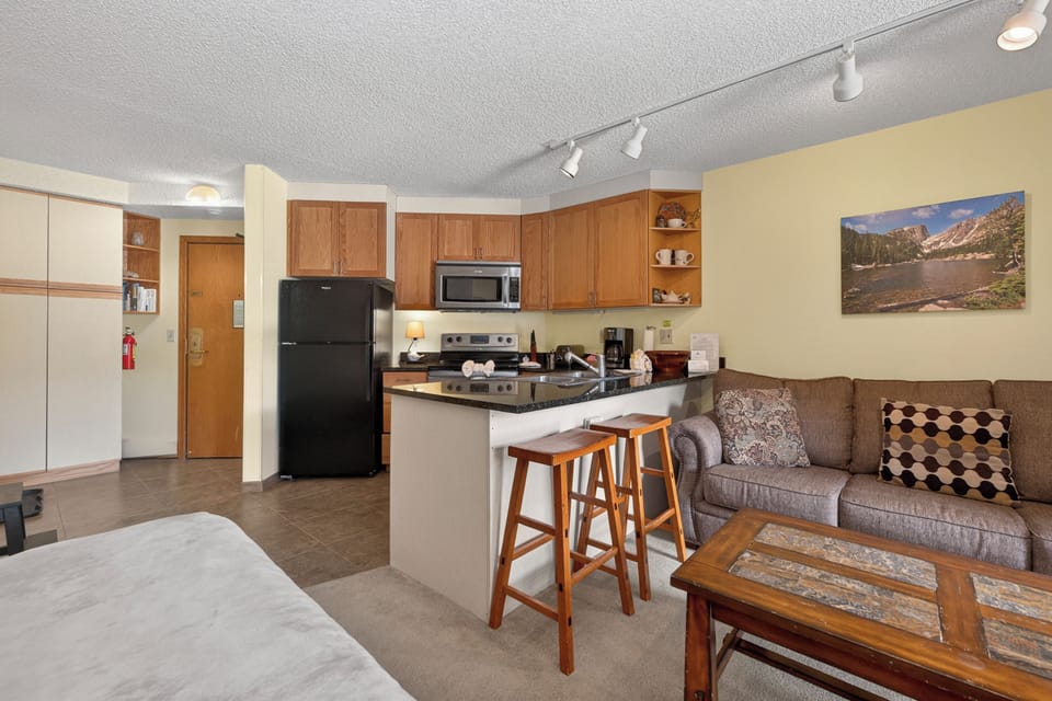 Your cozy retreat blends comfort and convenience with a fully-equipped kitchen, inviting living space, and mountain artwork that captures the spirit of your alpine getaway.
