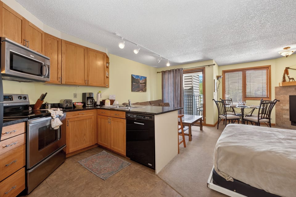 Your cozy studio blends comfort and convenience with a full kitchen, dining nook, and restful sleeping area—all bathed in natural light from a private balcony for mountain getaways.