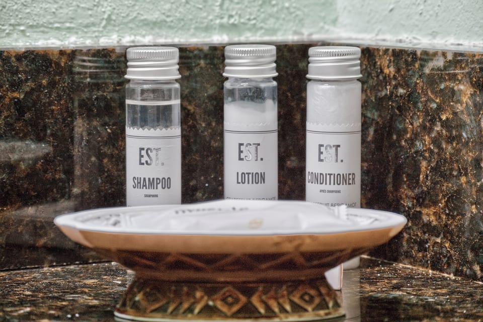 Step into your personal spa experience with premium toiletries waiting just for you—shampoo, lotion, and conditioner elegantly arranged for your refreshment.