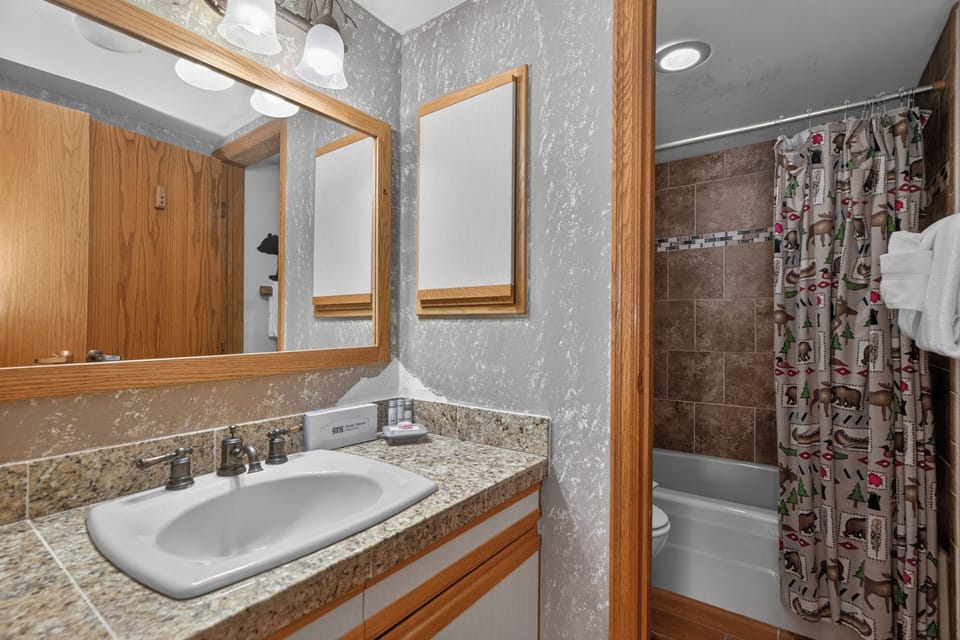 Unwind in your private bathroom with a spacious vanity, granite countertops, and a relaxing tub-shower combo after a day of adventure.