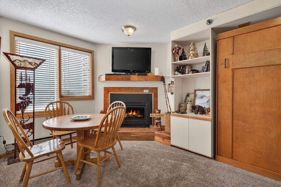 Gather around this cozy dining space where a warm fireplace sets the perfect ambiance for your meals and evening conversations, with entertainment and comfort at your fingertips.