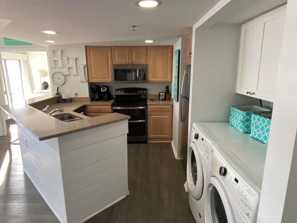 Kitchen with stainless steel appliances and full sized washer and dryer