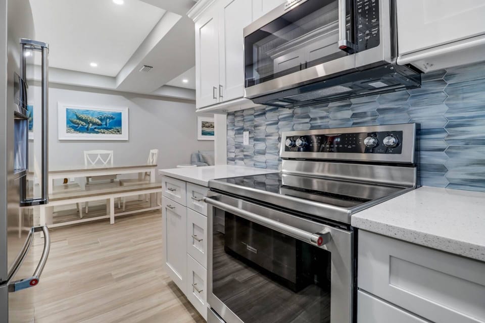 Completely remodeled kitchen boasts beautiful upgrades such as quartz counter tops, glass tile back splash, and full size stainless appliances.