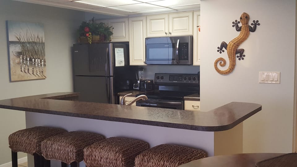 Black Stainless Kitchen Appliances and four barstools. 