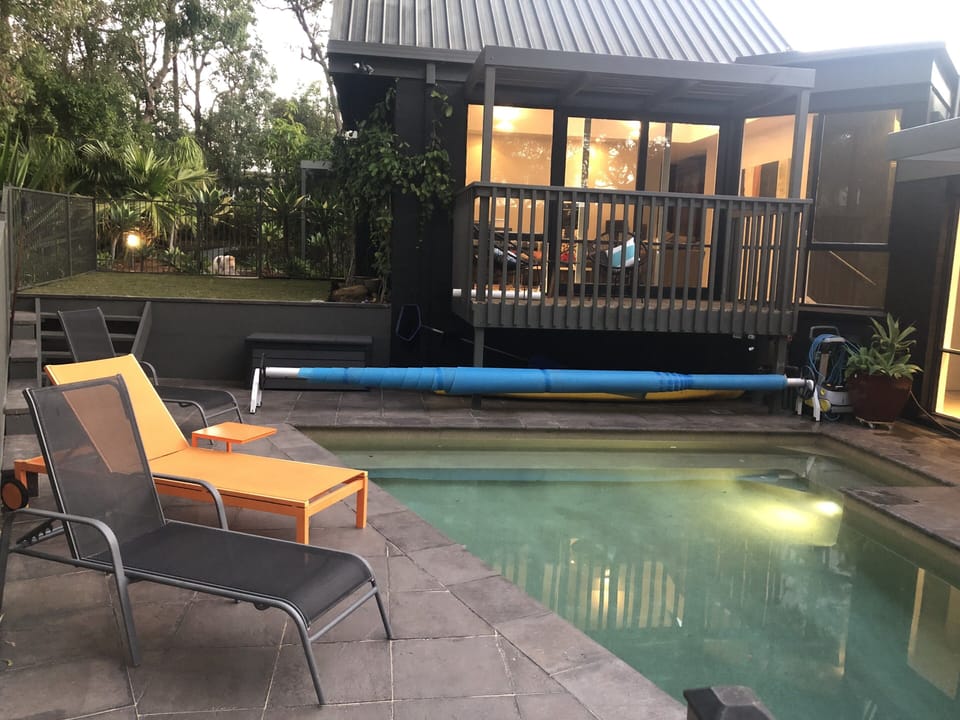 Fenced pool area with sun lounges.