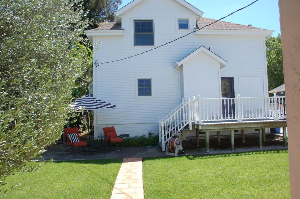 Back of house with private lounge area grassy leading to the relaxing hot tub.