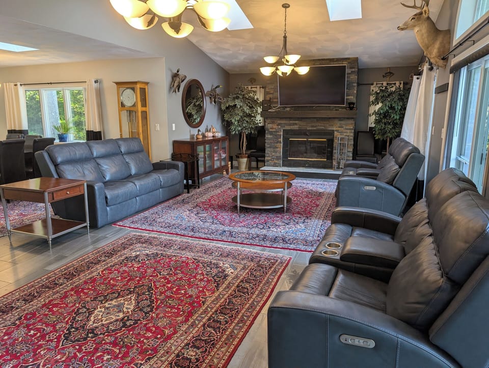 Living room with 3 sliders onto the deck and wood fireplace and skylights