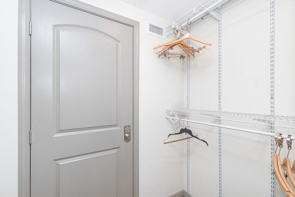 A thoughtfully designed walk-in closet offers plenty of room to hang and organize your wardrobe, with bright lighting and adjustable shelving for effortless convenience.