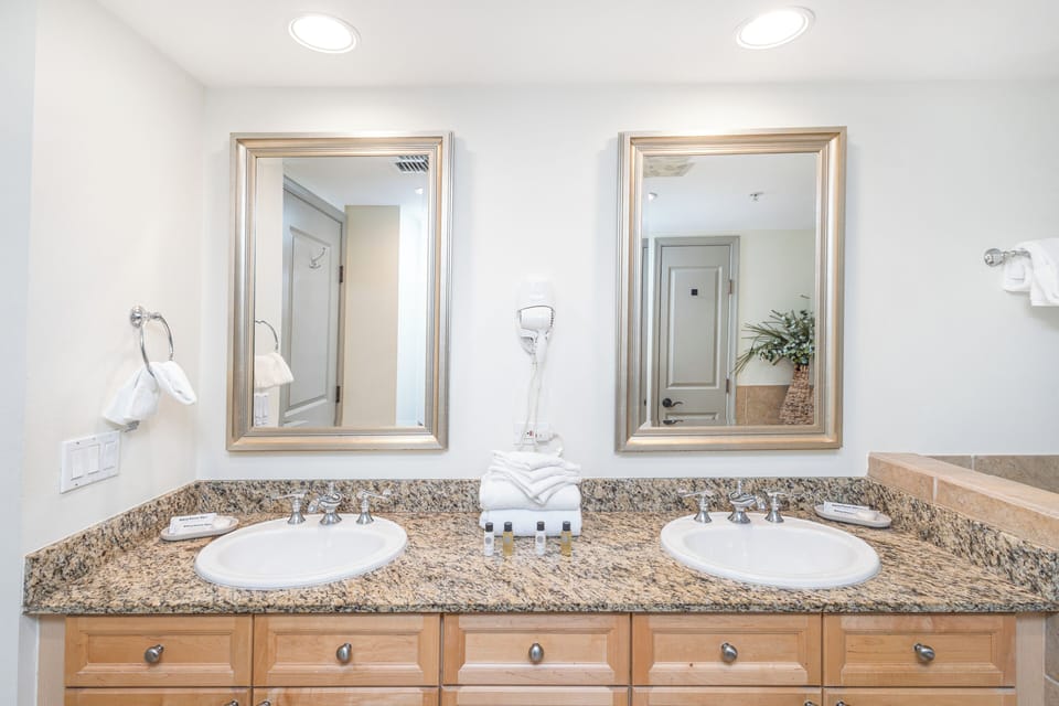Your spacious dual-vanity bathroom is bathed in natural light, with elegant granite countertops, fresh towels, and thoughtful amenities awaiting your arrival.