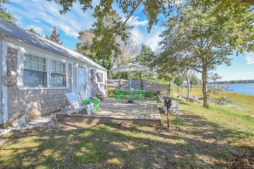 Porch at back of home with picnic table, overlooking cove