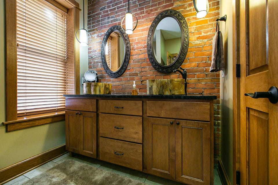 En suite bathroom with double vanity, glass shower and closet