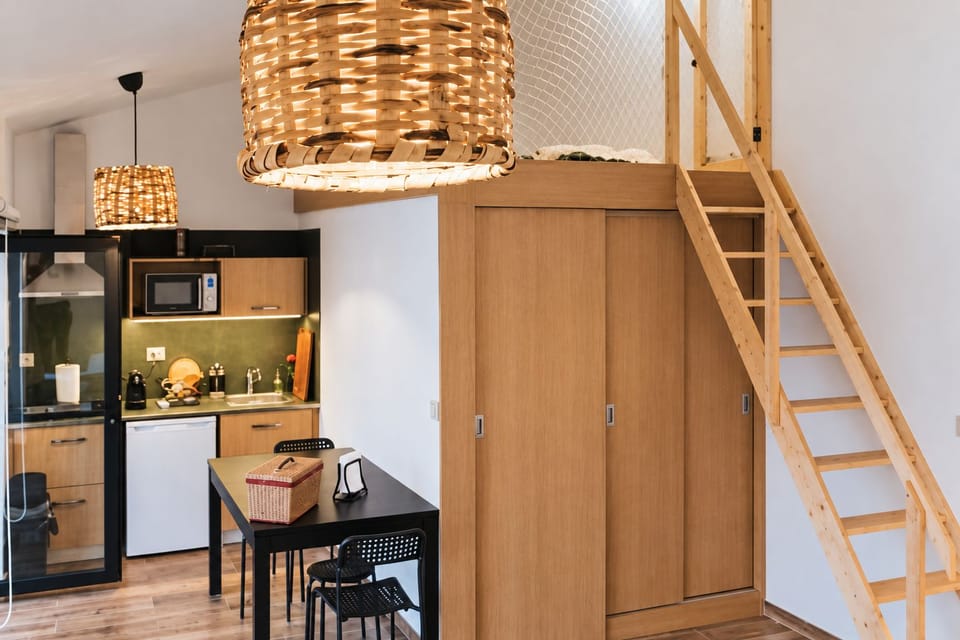 Kitchenette equipada e acesso ao mezanino, preparado com dois colchões individuais.