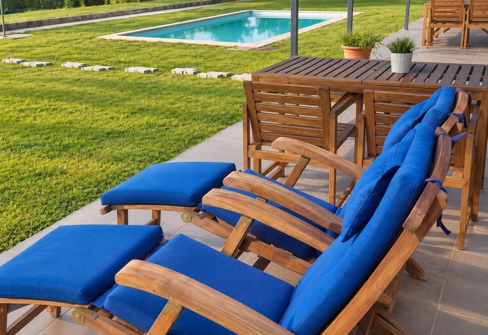 Terraço privado com espreguiçadeiras azuis e mesa de jantar, virado para a piscina. Um convite a mergulhos refrescantes e longos fins de tarde no Lugar nas Estrelas.