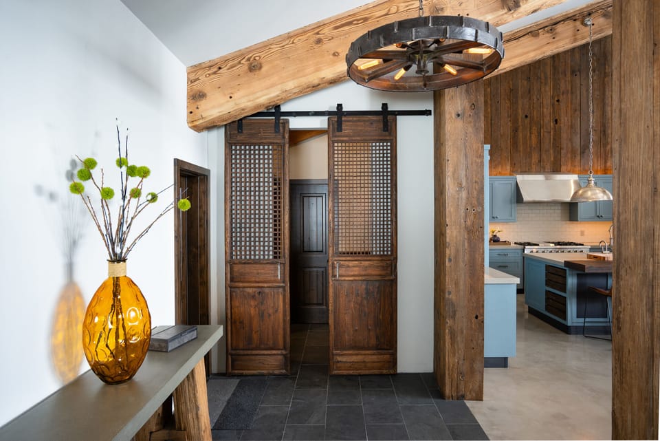 Antique doors are fitted to create barn door entry to the powder/laundry rooms.
