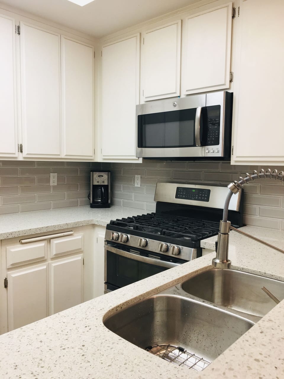 Oven & microwave w/ new quartz countertop, stainless steel sink & faucet. 