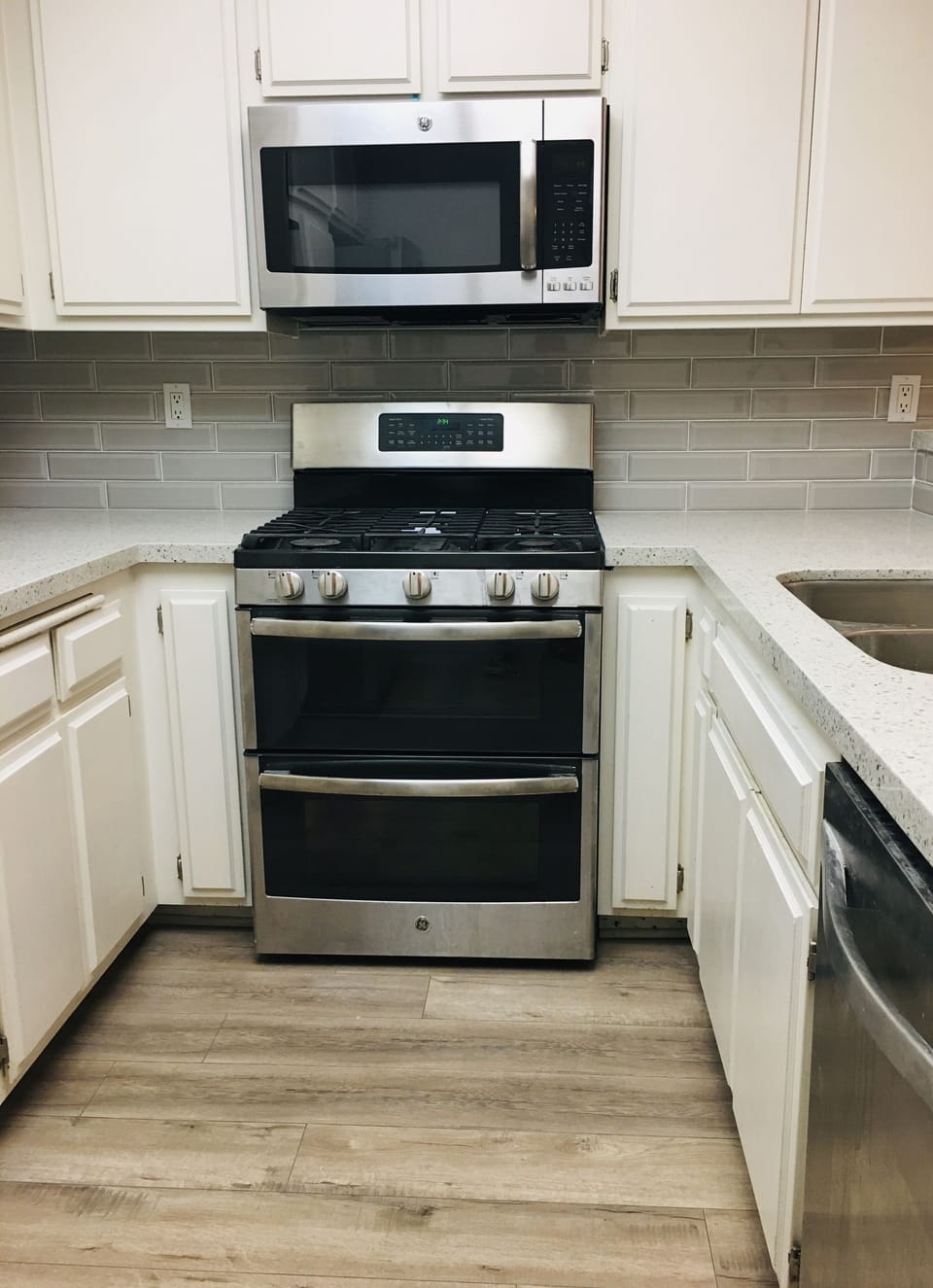 Gas double oven with microwave and dishwasher and new quartz countertop. 