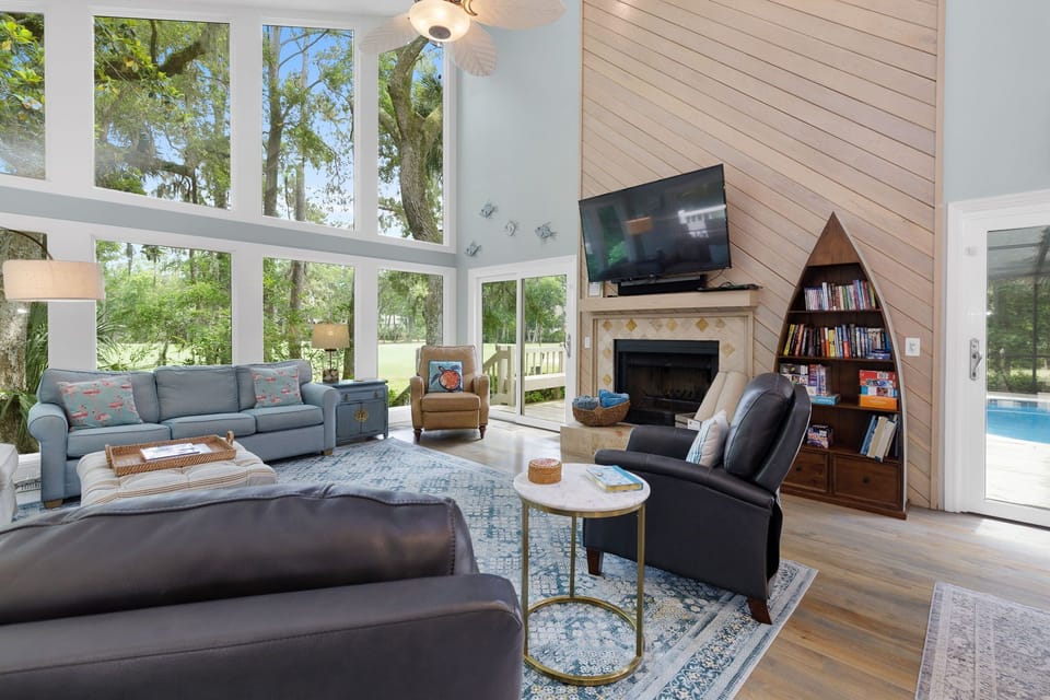 Spectacular living room with a wall of windows. It has 2 sofas & 3 recliners with a 65" 4K TV & Sonos sound system. It's the perfect place to watch nature or a movie after a day at the beach!