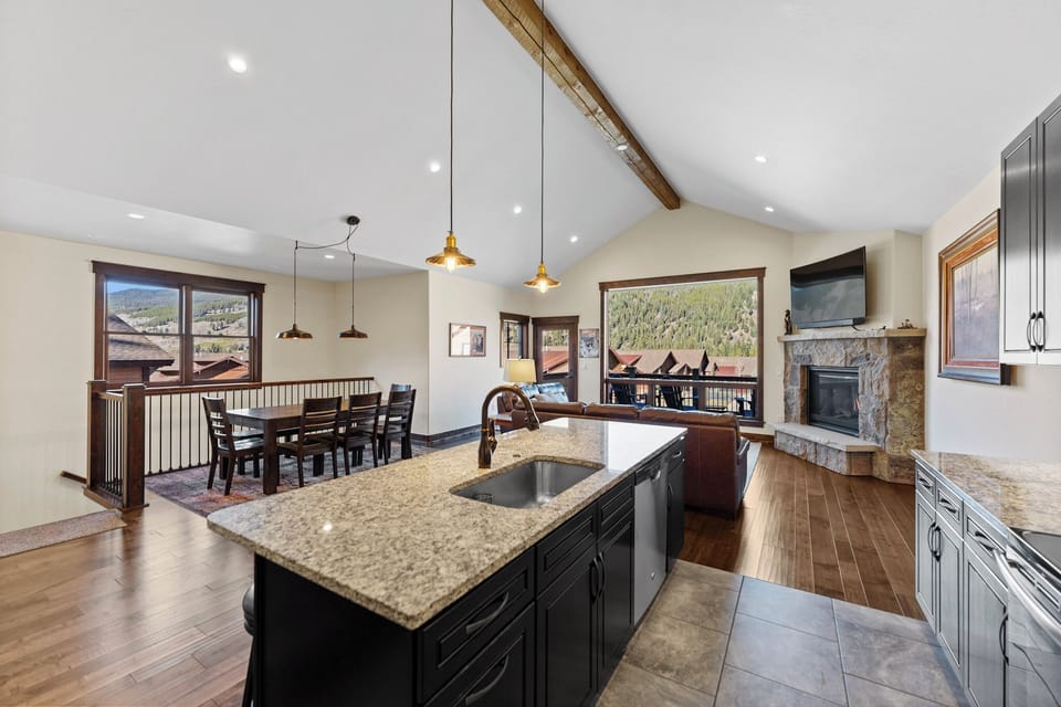 Your modern kitchen and living space features granite counters, vaulted ceilings, and stunning mountain views that create the perfect mountain retreat atmosphere.