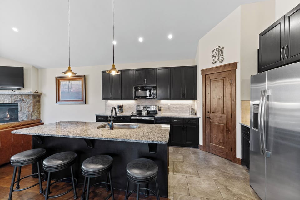 Your spacious kitchen features granite counters, stainless appliances, and a large island perfect for morning coffee or evening meals together.