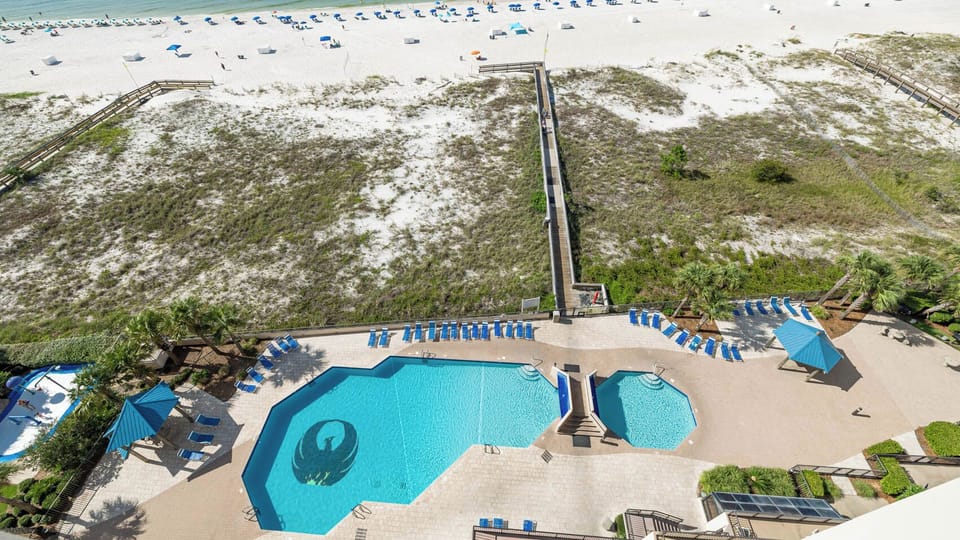Relax by the inviting pool surrounded by lounge chairs, with easy access to the beach just steps away
