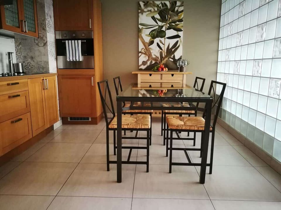 The same dining area from a different angle, showing the table with a plant centerpiece and the warm light creating a cozy atmosphere.