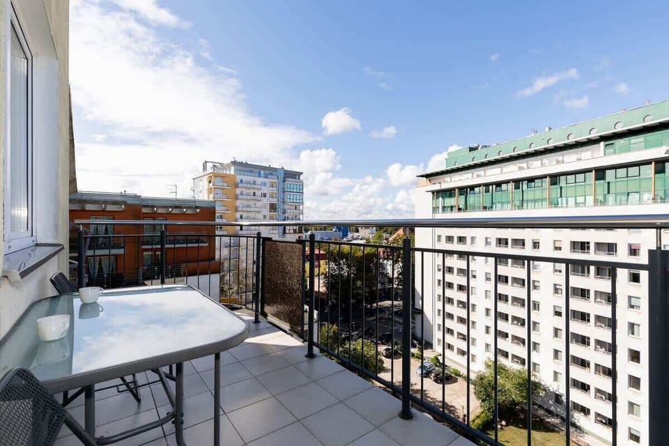 Another angle of the balcony showing a different view of the surrounding buildings, with a clear sky and natural lighting enhancing the outdoor space.