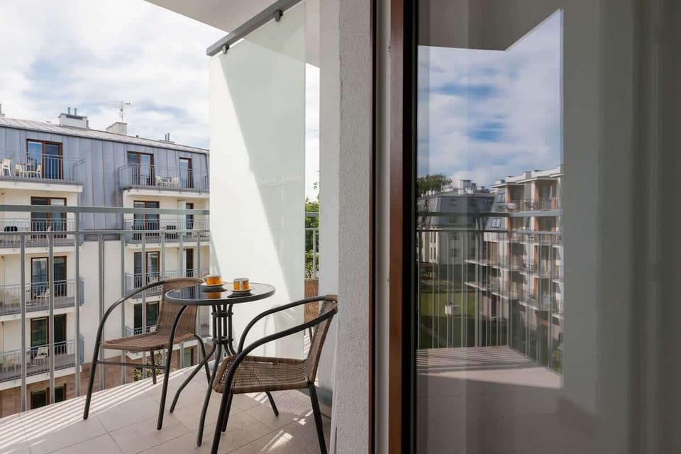The view from a balcony or terrace looking over a modern residential area. There's a small table with two chairs for enjoying the outdoor space.