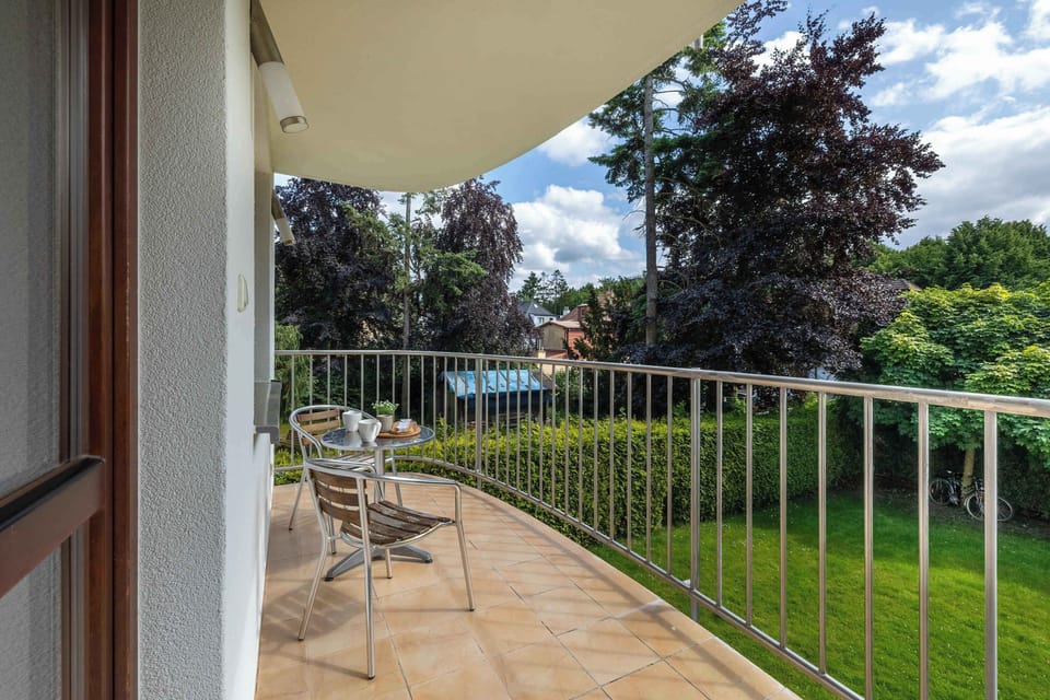 cFurnished balcony overlooking green surroundings.