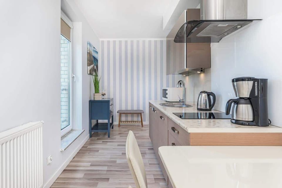 Functional kitchenette with toaster, coffee machine, microwave, and electric kettle.
