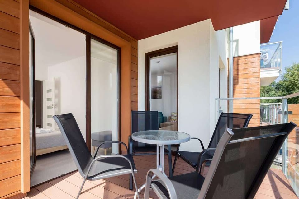 Balcony with tables and chairs that provide a comfortable space for relaxing outdoors.
