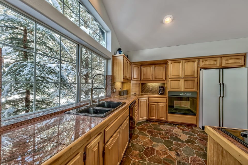 Cook your favorite meals in this stunning kitchen while gazing at snow-dusted trees through expansive windows.