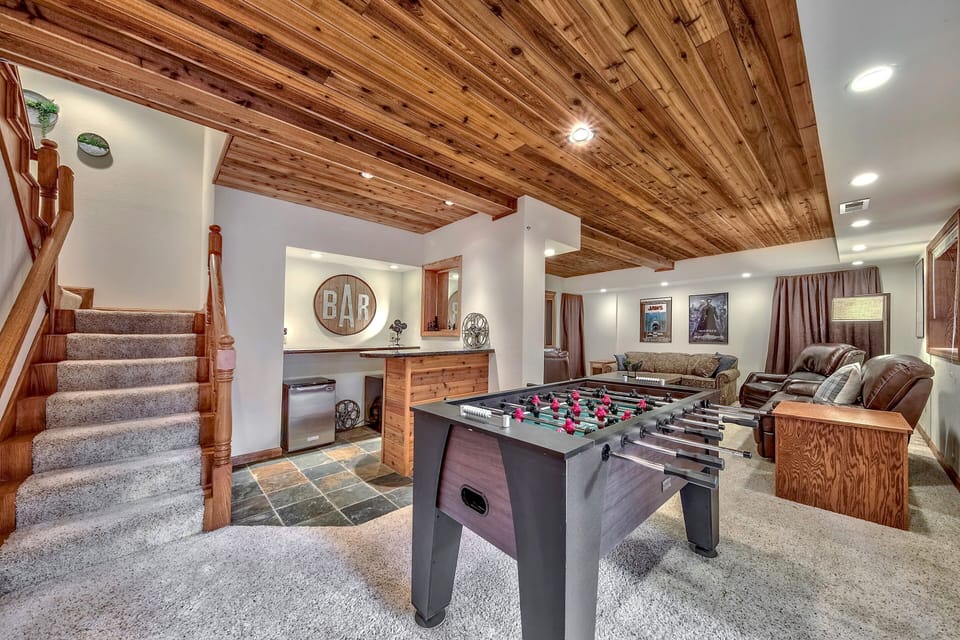 Your entertainment haven awaits with foosball fun, cozy seating, and rustic wood beams creating the perfect retreat atmosphere.