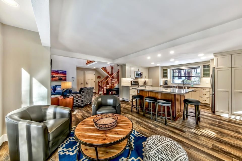 Sink into leather chairs beside your kitchen island where morning coffee flows into evening conversations in this open living space.