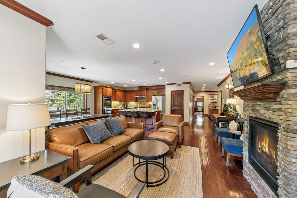 Relax in this stunning open-concept space where rich leather seating and a cozy stone fireplace create your perfect retreat.