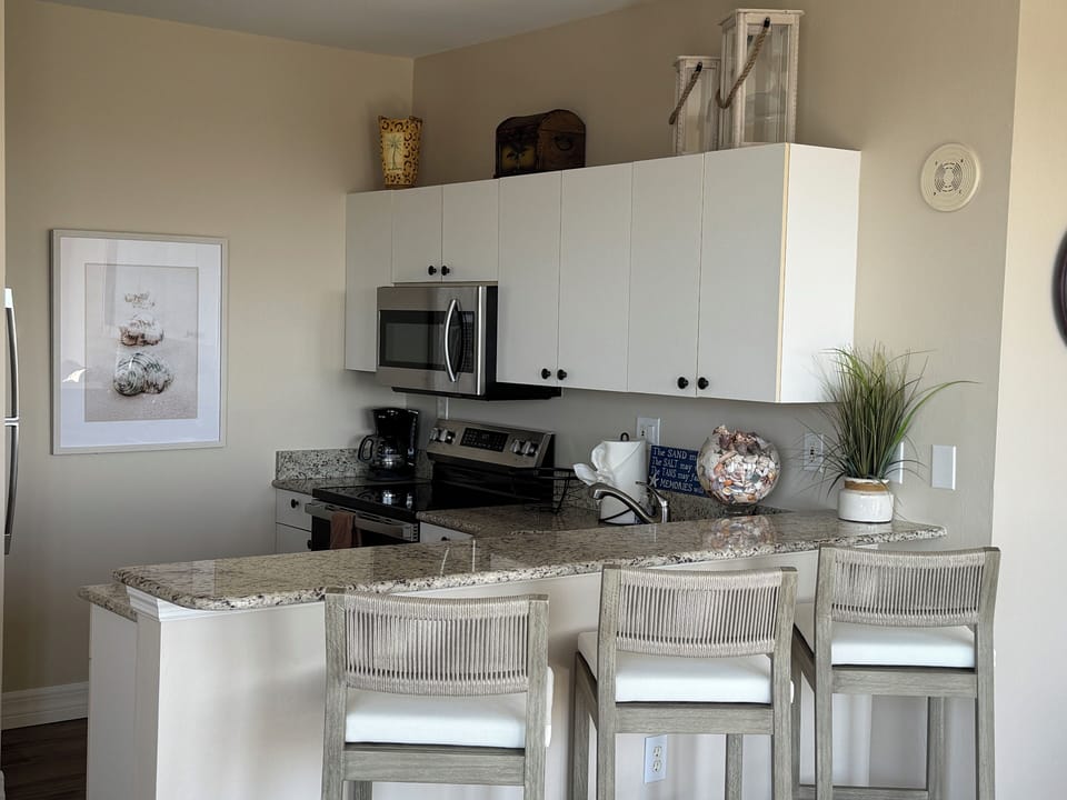 Kitchen with full size electric range, refrigerator and dish washer. 