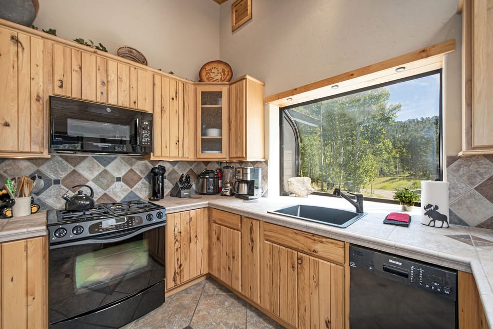 Kitchen is fully loaded with appliances and tools.