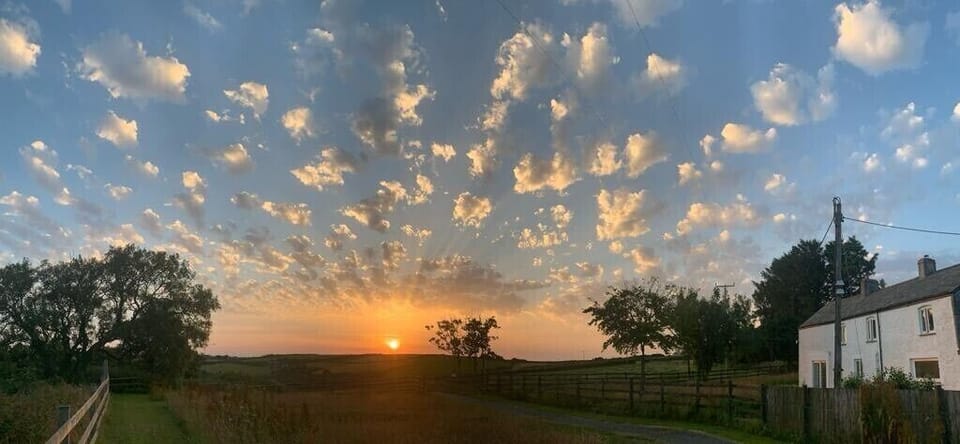 Summer sunrise behind the farmhouse