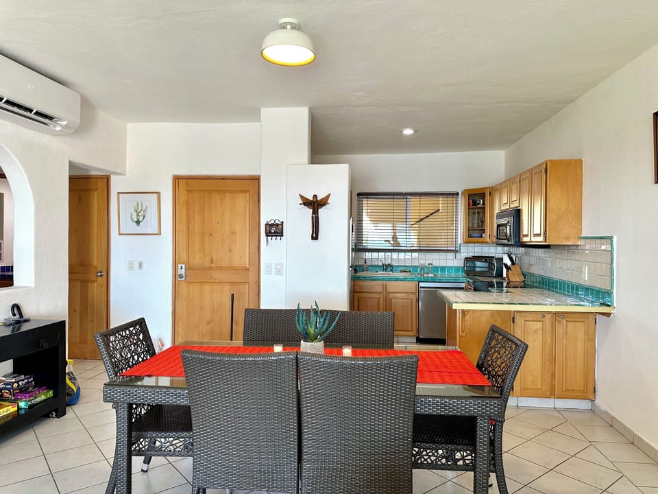 View from living room looking at main entrance door, kitchen, dining area