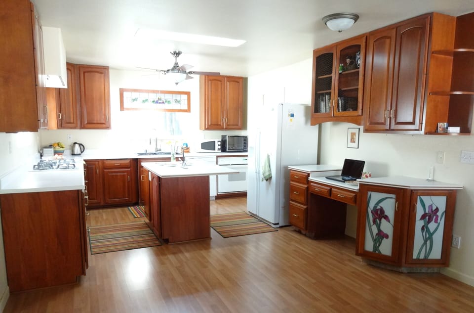 Kitchen area with new stove, sinks, counter tops.