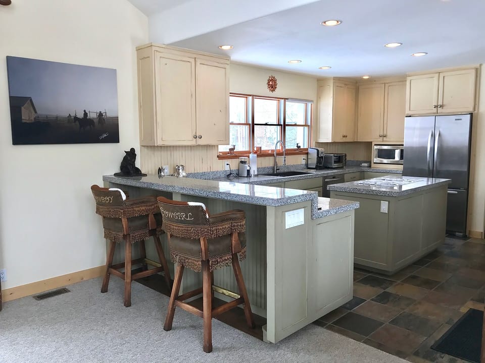 View of the kitchen w cowboy, cowgirl bar stools 