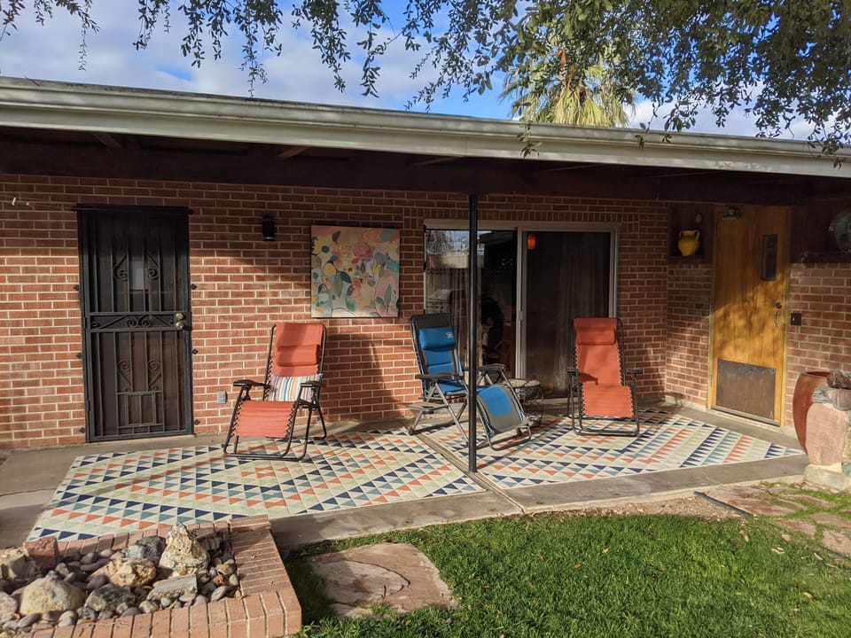 Rear patio onlooks grassed yard and pool
